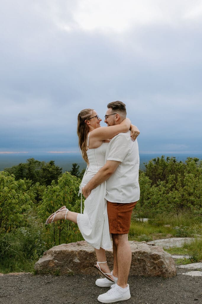 Couple posing for engagement photos at the top of Mount Agamenticus in York Maine